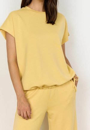 Haut à manches courtes en coton mélangé jaune avec un col rond, une coupe décontractée et un léger froncé à la taille, associé à un pantalon assorti à cordon de serrage.