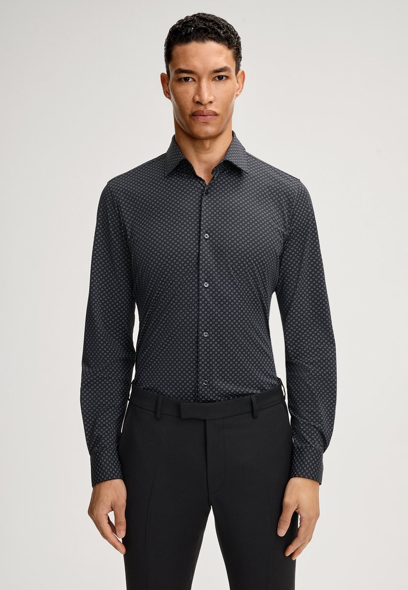 Czarna koszula zapinana na guziki z geometrycznym wzorem w ciemnym niebieskim kolorze. Posiada długie rękawy i kołnierzyk typu spread. Gładki materiał, slim fit.