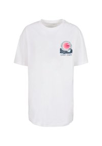 T-shirt bianco in cotone con maniche corte, caratterizzato da una grafica colorata di un sole e onde, e il testo “SUNSET CHARM” sotto il design.