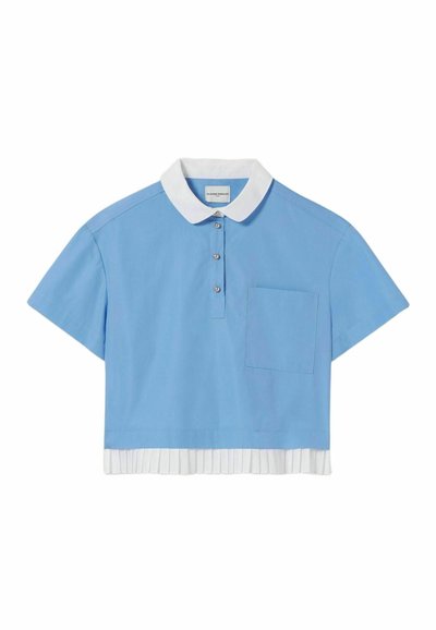 Polo corta azul con cuello blanco, mangas cortas, tapeta de botones y un dobladillo blanco plisado en la parte inferior. Presenta un bolsillo frontal.