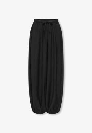 Pantalon large noir avec taille élastique et cordon, poignets froncés créant une silhouette ballon.