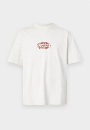 Weißes Baumwoll-T-Shirt mit Rundhalsausschnitt, kurzen Ärmeln und rotem ovalem "GUESS ORIGINALS"-Logo auf der Vorderseite. Einfaches Design, legere Passform.