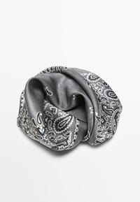 Szary jedwabny szal z białym wzorem paisley, elegancko skręcony w węzeł, o gładkiej, błyszczącej fakturze.