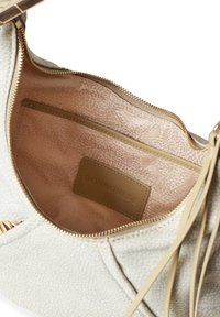 Hellbeige Handtasche mit einem strukturierten Außenmaterial. Das Innere ist mit einem glatten rosa Futter, einer Reißverschlusstasche und einem Markenlabel ausgestattet.