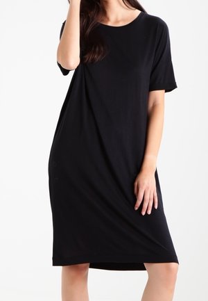 Robe t-shirt noire en tissu doux, à manches courtes, col rond, longueur genou avec des accents de boutons sur les côtés. Simple, coupe décontractée.