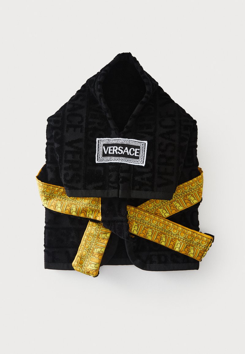 Halat de baie Versace negru cu glugă, cu model cu logo embossat și curea aurie cu model, legată în jurul taliei, așezat plat pe un fundal alb.