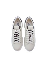 Vita sneakers i slät läder, med bruna accenter, vita snören och tryckt logotyp på tungan. Klassisk lågskor design.