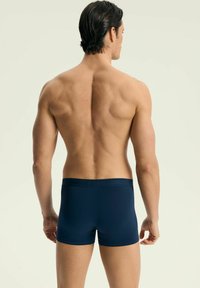 Granatowe majtki wykonane z miękkiego, elastycznego materiału. Charakteryzują się dopasowanym krojem, bezszwowym paskiem w talii oraz gładką teksturą.