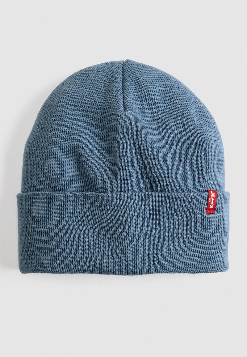 Blue knitted beanie hat with a folded cuff, made of soft material, featuring a small red Levi's logo tag on the side.