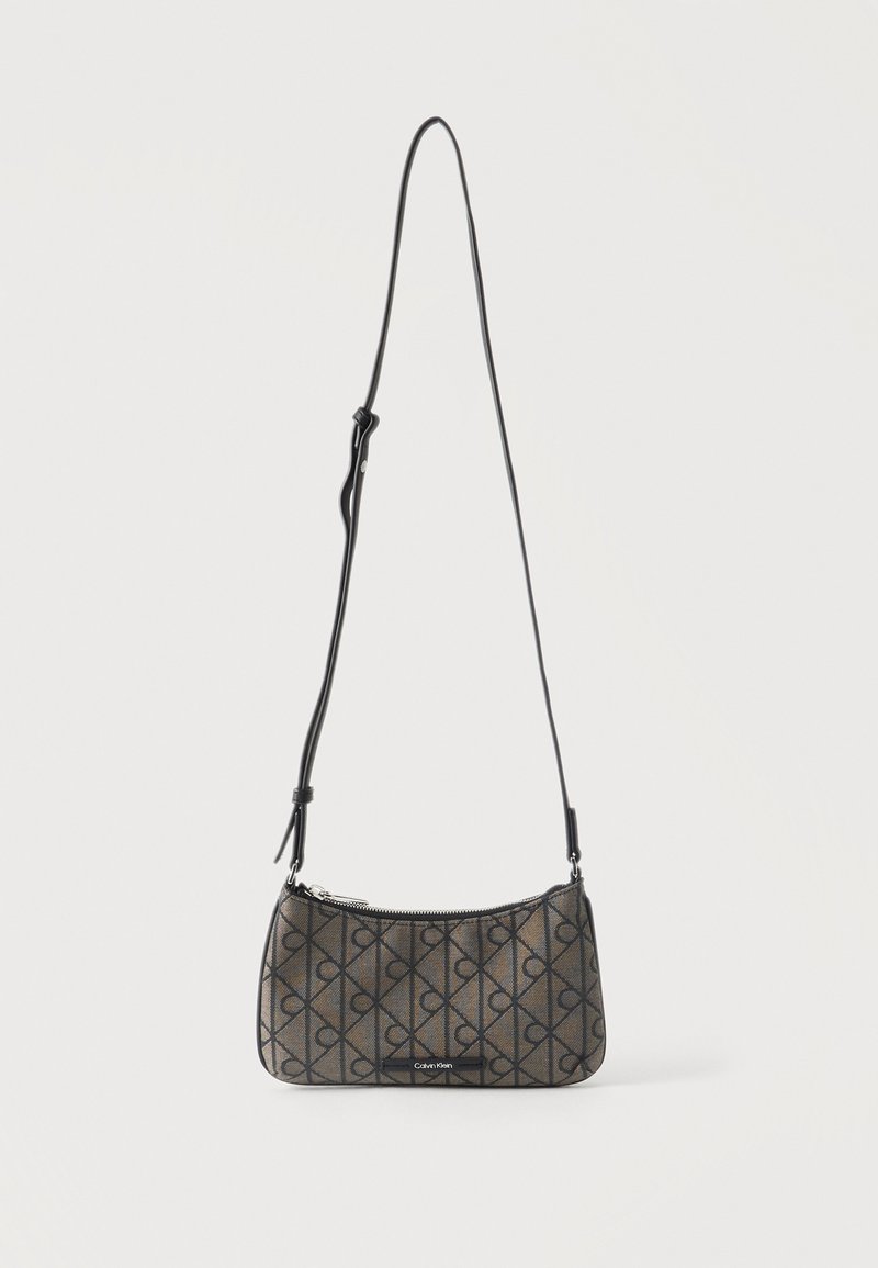 Μικρό τσαντάκι ώμου Calvin Klein με ρυθμιζόμενο μαύρο λουρί, καφέ ύφασμα με επαναλαμβανόμενο μοτίβο λογότυπου και κλείσιμο με φερμουάρ στην κορυφή.