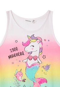 Top bianco senza maniche che sfuma dal rosa ai colori dell'arcobaleno. Presenta una grafica di unicorno con paillettes, conchiglie e piccoli creature marine. Il testo recita "%100 MAGICO."