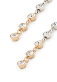 Ohrringe aus Gold- und Silberschmuck mit runden, facettierten klaren Kristallen, die in einem alternierenden Muster verbunden sind. Das Design ist schick und modern.