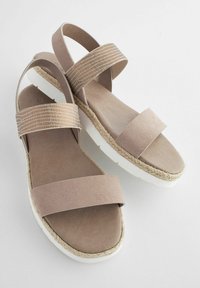 Ljusbruna espadrille-sandaler med två breda remmar, varav en har en strukturerad design. Tjock vit sula med jutefoder. Slät yta.