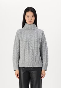 Pull en maille torsadée gris clair avec un col montant, des poignets et un ourlet côtelés. Présente des motifs texturés sur l'ensemble et un design ample.