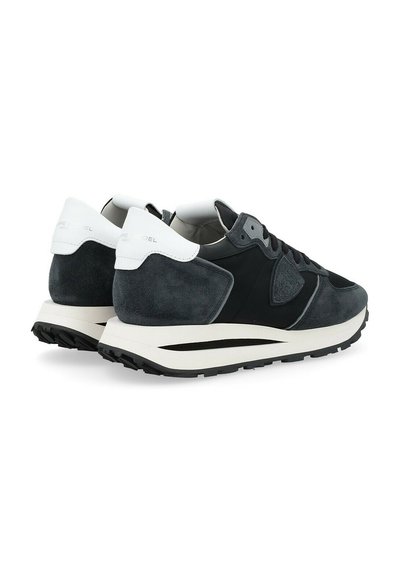 Sneaker in suede nero e grigio con linguetta imbottita, dettagli bianchi sul tallone e una spessa suola intermedia bianca con suola esterna nera textured.