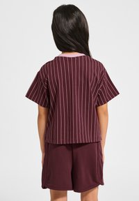 Vinröd randig t-shirt med korta ärmar och rosa krage, i kombination med matchande vinröda shorts. Bomullstyg, avslappnad passform.