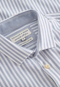 Camicia a strisce blu chiaro e bianca con colletto button-down, chiusura a bottone piccola e etichetta con la scritta "Colours & Sons."
