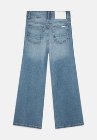 Ljusblå jeans med vida ben, med en solid baksida som har två fickor och en vanlig vit lapp vid midjan.