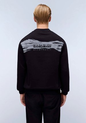 Felpa nera con un design a pennellate grigie sulla parte superiore della schiena, con testo "NAPAPIJRI geographic" in colori contrastanti.