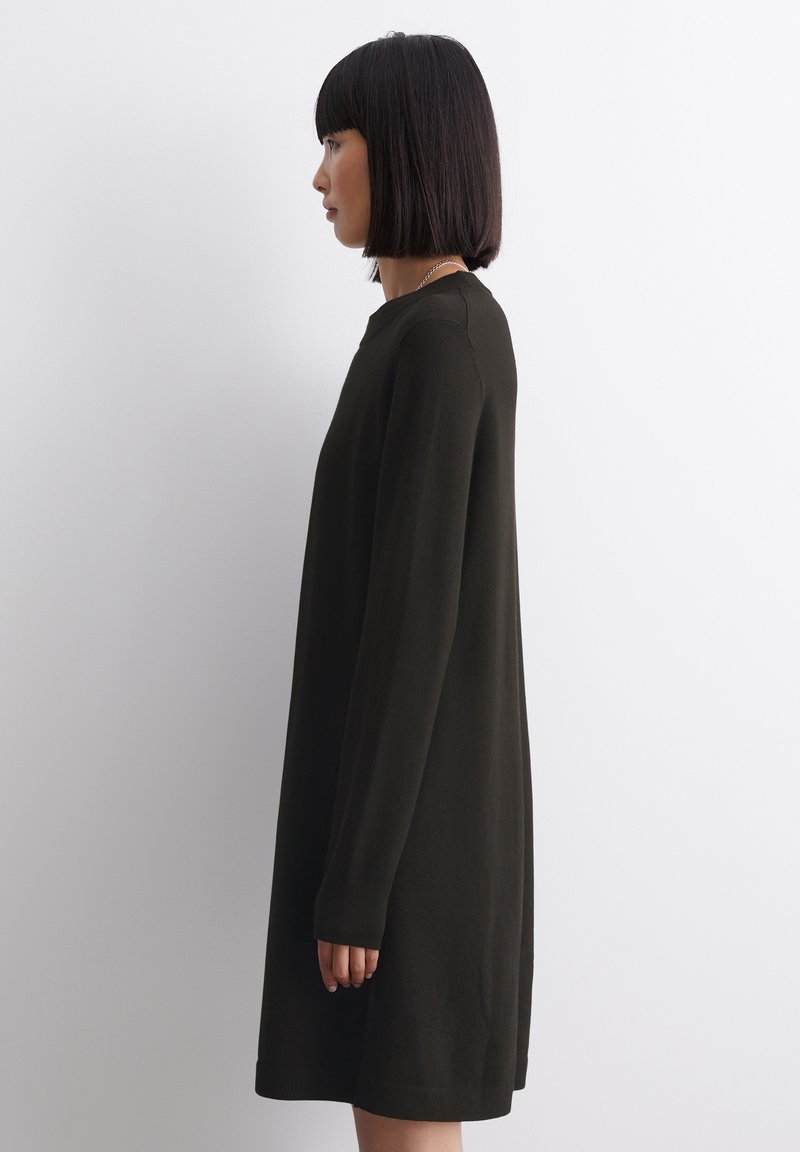 Langärmliges, dunkelolivgrünes Kleid mit lockerer Passform, rundem Halsausschnitt und gerippten Bündchen. Glatte Textur und knielang.