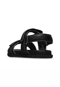 Zwarte leren sandalen met open zijkanten, verstelbare banden en een gestructureerde rubberen zool. Gestikte accenten benadrukken de ontwerpkenmerken.