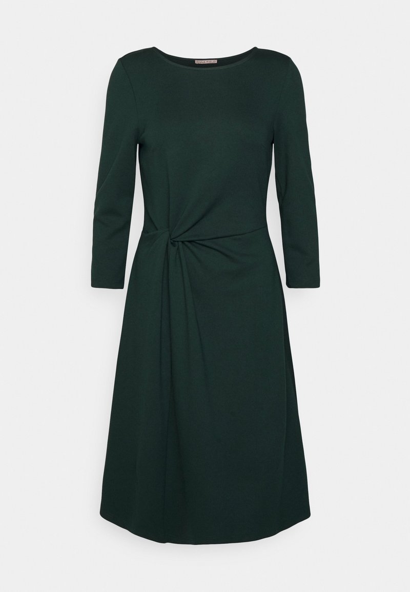Robe midi à manches longues vert foncé avec encolure ronde et un détail torsadé sur le côté créant un effet drapé subtil.