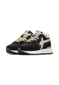Un paio di sneaker nere e beige con suole testurizzate, logo a stella beige sui lati, lacci beige e etichette brandizzate sulla linguetta che recitano "W6YZ."