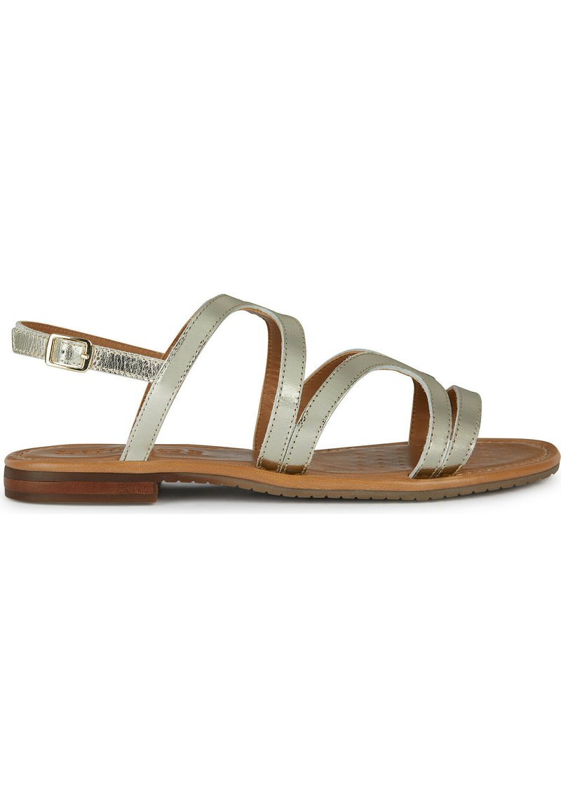 Sandalias de color plateado metálico con tres correas delgadas, hebilla ajustable en el tobillo y una plantilla texturada de color marrón claro. Suela de goma plana.