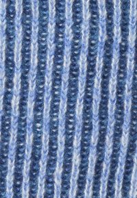 Primo piano di un tessuto in lana blu e bianco che mostra un motivo di maglieria a coste verticali con una texture morbida e pelosa.