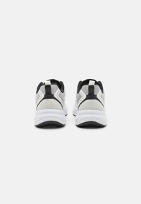 Sporta apavi ar baltu un melnu krāsu shēmu, sietveida augšdaļu, mīkstu apkakli un biezu baltu zoli. Iekļauts vilkšanas cilpa uz papēža.