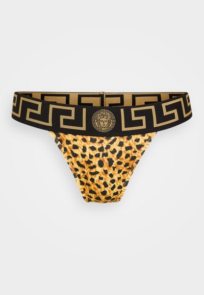 Leopardprint string met een gouden en zwart gestreepte tailleband met een centraal logo-embleem. Materiaal lijkt glad en rekbaar.