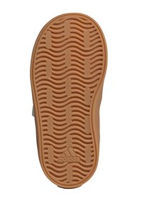Suela de zapato Adidas con un patrón texturizado ondulado, de color marrón claro, y logo grabado en la parte inferior. Los bordes son redondeados y suaves.