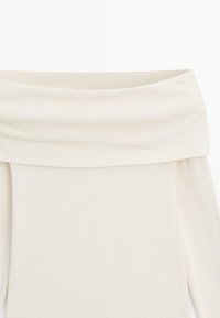 Top z odkrytymi ramionami w miękkiej, kremowej tkaninie. Posiada szeroki, złożony dekolt i długie rękawy, z gładką, lekką teksturą.