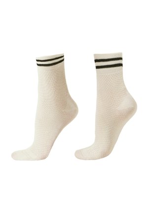 Para beżowych skarpetek do kostek z dwoma ciemnymi poziomymi paskami w pobliżu mankietu, ułożonych obok siebie na białym tle.