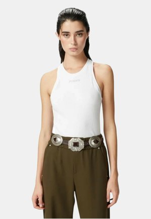 Top in cotone bianco a coste con scollatura alta e discreto logo "PINKO", abbinato a pantaloni verde oliva e una cintura decorativa in argento.