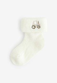 Hvid bomuldsstrømpe med ribbet manchet, der har et broderet traktor-design i beige og lys blå. Blød tekstur, klassisk form.