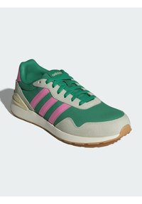 Grön sportskor med rosa ränder, texturerad mesh-ovandel, vadderad krage, snörning och en beige gummisula.