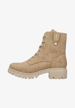Beige ankle boot with faux suede material, round toe, lace-up design, and textured sole. Features a logo accent and a block heel.