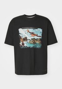 Black cotton T-shirt featuring a vibrant printed design of Icarus with a blue sky and landscape, text reads "LEGACY OF ICARUS."