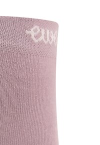 Helle rosa Socke mit gerippter Textur und einem weißen Logo, das am Bündchen gestickt ist. Das Design ist glatt und kann sowohl lässig als auch formell getragen werden.