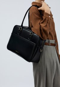 Schwarze Lederhandtasche mit zwei goldfarbenen Beschlägen und Reißverschluss. Verfügt über zwei Griffe und ein elegantes, strukturiertes Design.