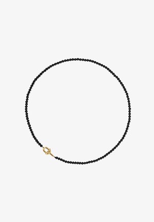 Collar de cuentas negras con una textura suave, que presenta un cierre de metal dorado. El diseño enfatiza la simplicidad y la elegancia.