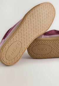 Lila och beige sneakers med en texturerad gummisula. Har ett zickzackmönster på överdelen och "NEXT"-logotyp på sulan.