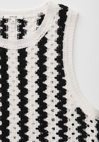 Haut en crochet blanc sans manches avec des rayures noires ondulées verticales et un col rond, taille 36.