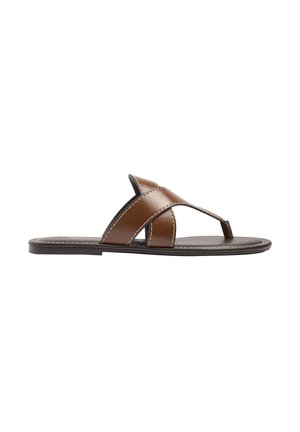 Brązowy płaski skórzany sandał z szerokimi krzyżującymi się paskami i międzypalcowym paskiem na czarnej podeszwie na białym tle.