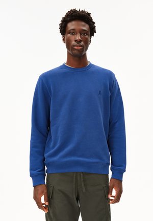 Blauer Pullover mit rundem Halsausschnitt, langen Ärmeln, weichem Material und einem kleinen blauen Ripsband-Detail auf der linken Brustseite.