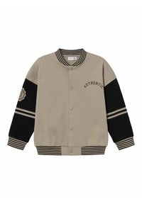 Veste universitaire beige avec manches noires. Présente un col et des poignets côtelés, des boutons pressions, et le texte "AUTHENTIC" au-dessus du côté gauche.