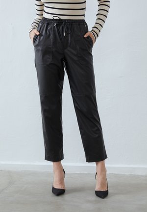 Sorte læderbukser med elastisk talje og snor, der har sidelommer og en tætsiddende design. Glat tekstur og cropped længde.