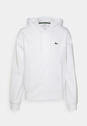 Sweat à capuche blanc zippé avec poches devant, capuche avec cordon, poignets côtelés et petit logo crocodile vert sur la poitrine.