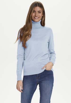 Pull à col roulé bleu clair avec des accents côtelés au niveau de l'encolure et de l'ourlet, en tissu doux, assorti avec un jean bleu foncé.